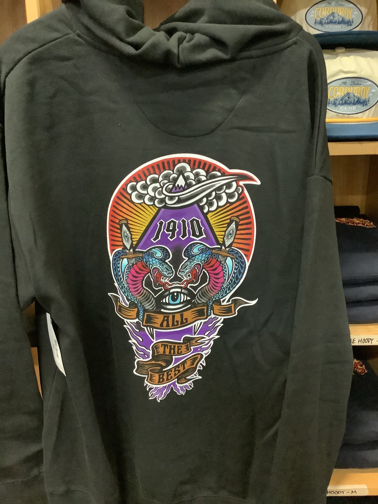 Black hoodie with colorful graphic design on a wooden surface