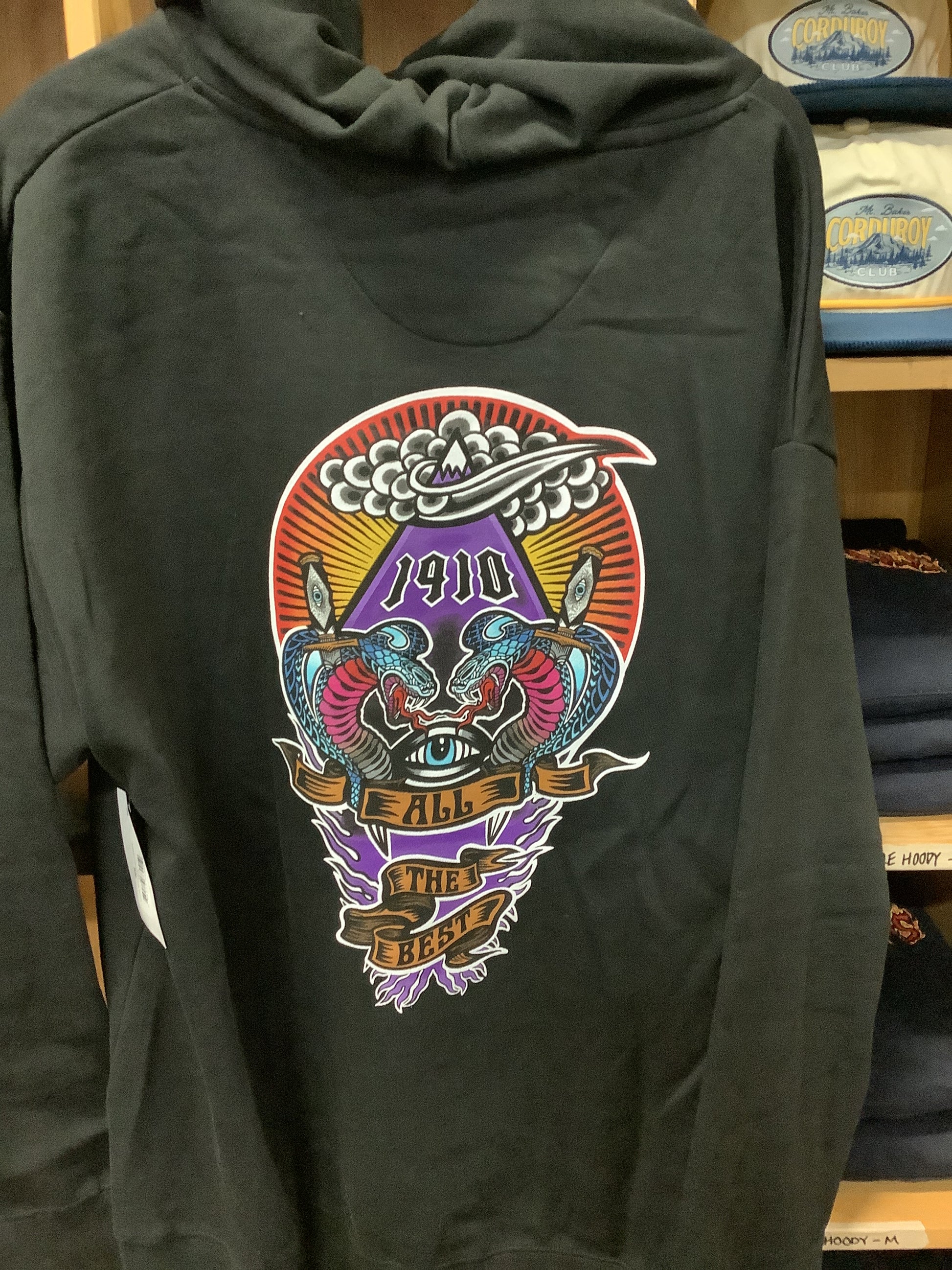 Black hoodie with colorful graphic design on a wooden surface