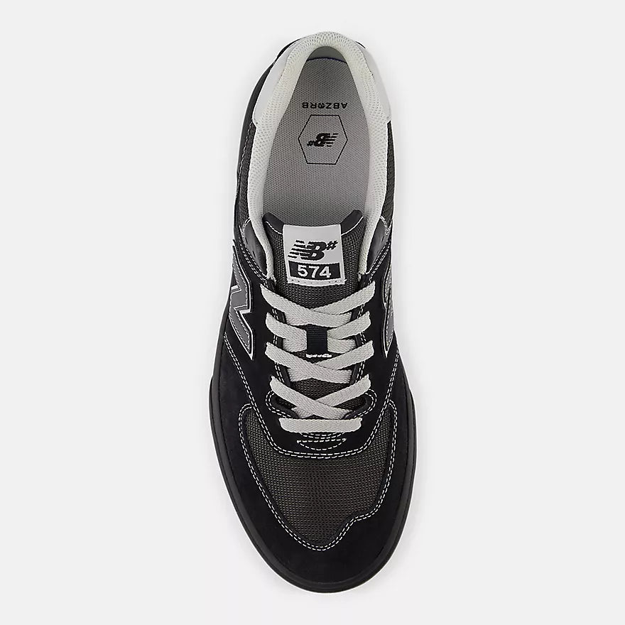 Black sneaker with white laces and New Balance logo on a white background