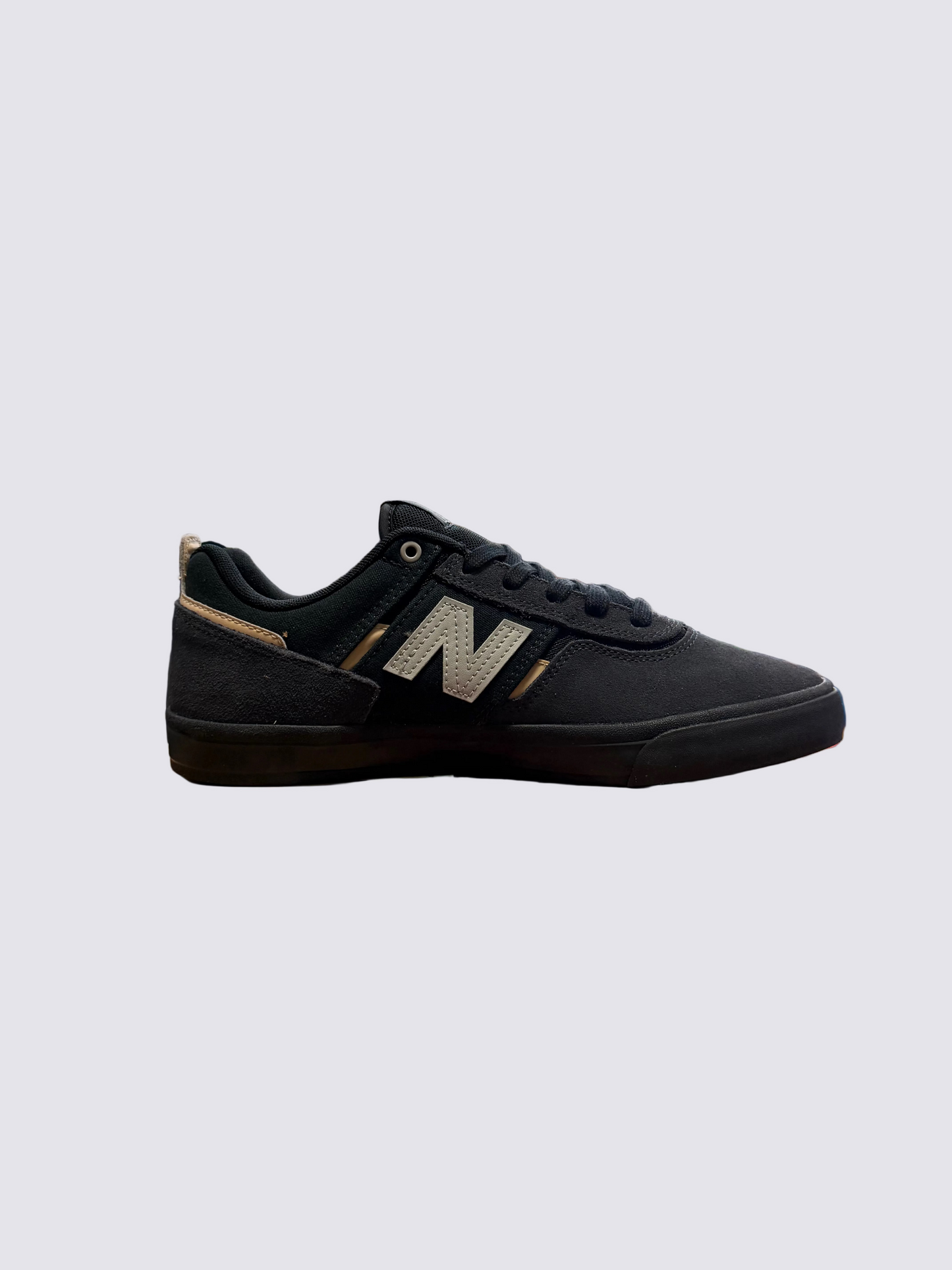 Black New Balance sneaker on a red box in a store setting
